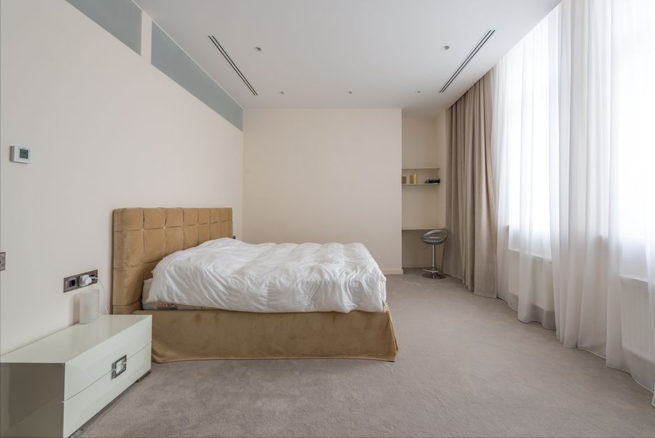 A quiet, uncluttered bedroom in soft neutral light