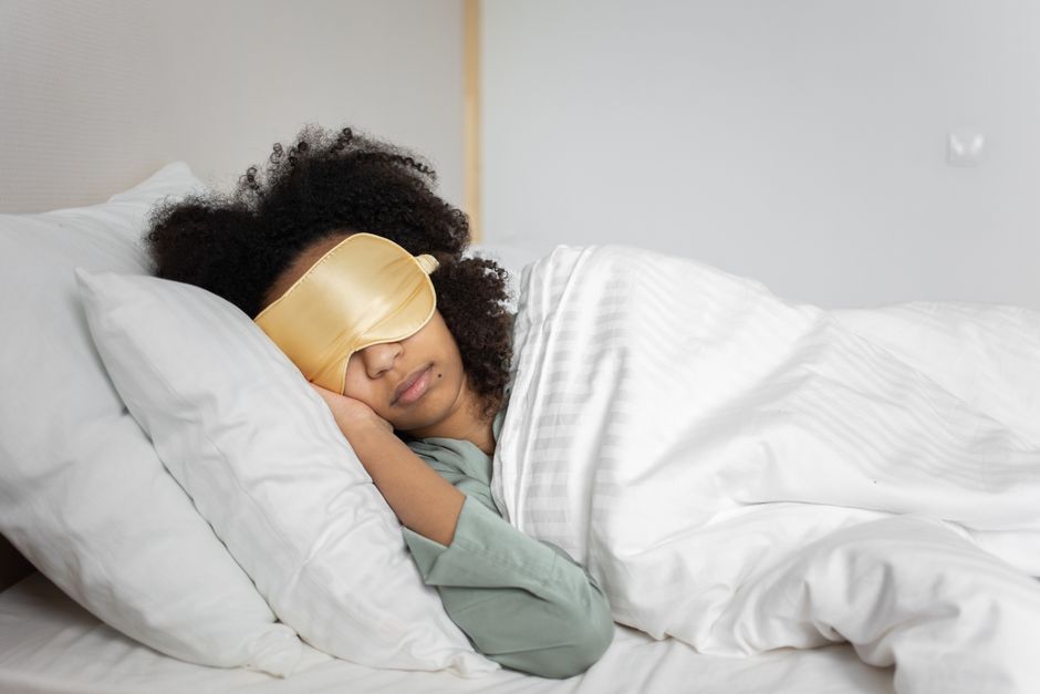 Sleep mask worn by a side sleeper in bed