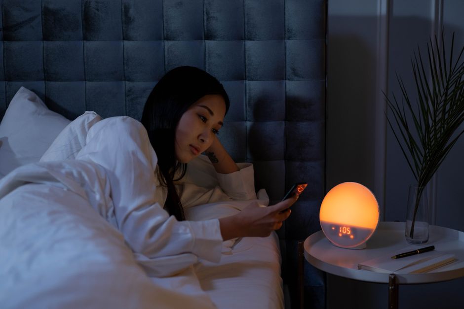 Sunrise alarm clock glowing warmly on a bedside table